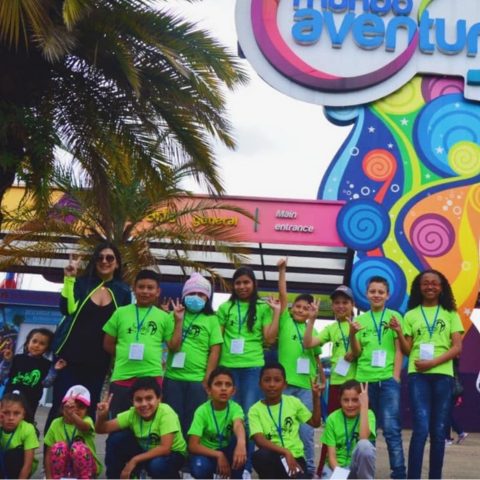 Niños y niñas con camisetas verdes posan a la entrada del parque Mundo Aventura.